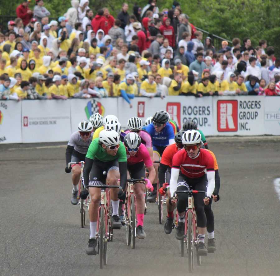 The lead group of riders racing down one of the tracks straightaways. 