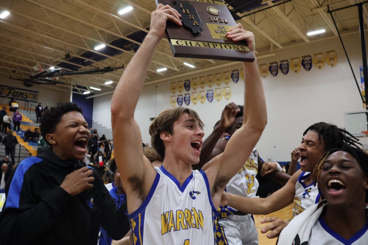 Junior Jack Wolf hosting regional plaque to the air, after defeating Waukegan 67-55 